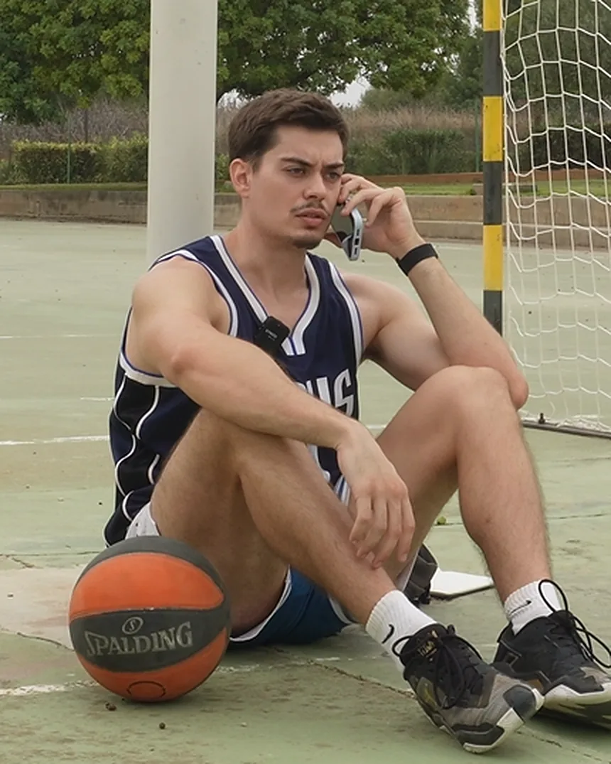 Adrián sentado en una pista, hablando por teléfono
